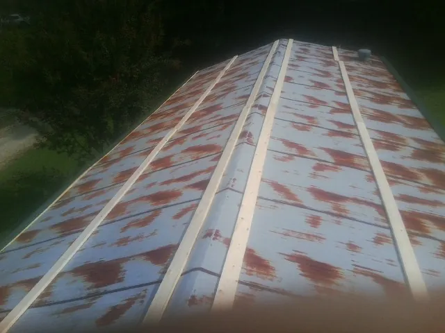 Rusted metal roof panels with new wood purlins before replacement — Storm Damage Roof Repair in Debary by Roofing Brothers
